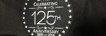 Das Emblem zur 125-Jahr-Feier der American & Efird auf schwarzem Stoff.